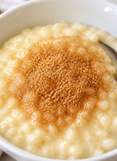 Bowl of creamy Fast German Milchreis topped with cinnamon sugar and fresh berries.