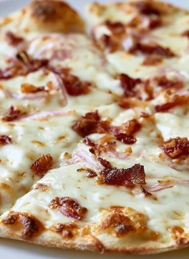 Homemade Flammkuchen topped with onions and bacon, a German Tarte Flambée dish.