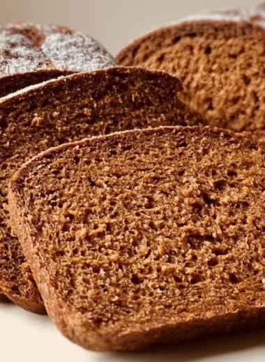 Freshly baked Schwarzbrot, a traditional German rye bread, on a wooden table.