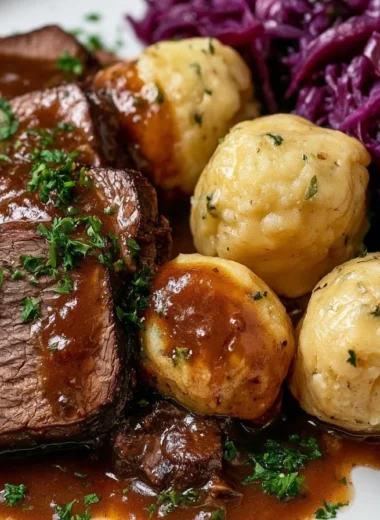 Delicious traditional Sauerbraten served with dumplings and gravy